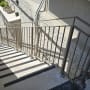 מעקה מתכת על מדרגות חיצוניות עם צללים