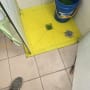 רצפת מקלחת צבועה בצהוב עם דלי כחול