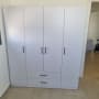 ארון בגדים עם דלתות ומגירות מותקן בחדר