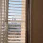 תריסים לבנים פתוחים בחלון עם נוף חיצוני