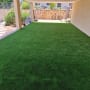 דשא סינתטי פרוס בחצר עם כלי גינון בצד
