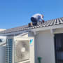 אדם עובד על גג עם מערכת מיזוג אוויר