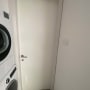 דלת לבנה עם ידית מתכת בחדר כביסה