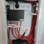 ארון תקשורת עם כבלים אדומים ושקעי חשמל