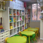 חדר ילדים עם מדפים, צעצועים ושולחנות צבעוניים