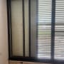חלון אלומיניום עם תריסים סגורים בחדר פנימי