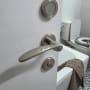 ידית דלת מתכתית בחדר אמבטיה עם שירותים