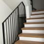 מדרגות עץ נקיות עם מעקה מתכת שחור