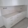 ארונות מטבח לבנים עם משטח עבודה ושיש
