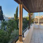 מעקה מתכת על מרפסת עם עמודי עץ