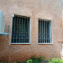 שני חלונות עם סורגים על קיר חיצוני