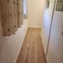 רצפת פרקט חדשה במסדרון צר עם קירות לבנים