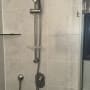 ראש מקלחת ומתקן תלייה בחדר אמבטיה