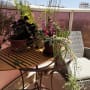 שולחן עם עציצים במרפסת שטופת שמש