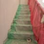 מדרגות מכוסות בניילון ירוק ואדום לשיפוץ