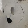 סדקים וחור בקיר לבן עם סימני רטיבות