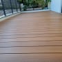 wooden deck with plants in the background