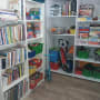 מדפים עם ספרים, משחקים וצעצועים מאורגנים בקופסאות