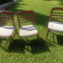 כיסאות עץ עם ריפוד בהיר על דשא ירוק