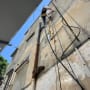 אדם עובד על צינורות חיצוניים של בניין
