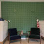 שני כיסאות מול קיר עם טפט ירוק דוגמת עיגולים