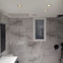 חדר אמבטיה משופץ עם תאורה שקועה וקירות שיש