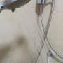 shower head with water flowing, metal hose, and wall mount