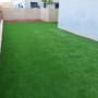 דשא ירוק מלאכותי בחצר מגודרת