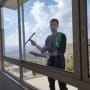 אדם מנקה חלון עם מגב ובד ירוק