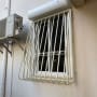 סורגי מתכת לבנים על חלון קיר חיצוני