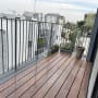 מרפסת עם רצפת עץ ועציצים לאורך המעקה