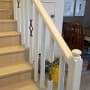 מעקה מדרגות צבוע בלבן עם עיטורים חומים