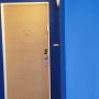 דלת עץ עם קירות צבועים בכחול