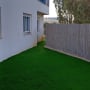 דשא סינתטי ירוק ליד גדר במרפסת