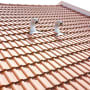 אריחי גג אדומים עם צינורות מתכת בולטים