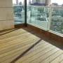 רצפת עץ במרפסת עם מעקה זכוכית
