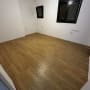 רצפת פרקט עץ בחדר ריק עם קירות לבנים