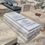 מצבות אבן עם כיתוב בעברית ובאנגלית בבית קברות