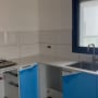 מטבח בשיפוץ עם ארונות כחולים וכיור מותקן
