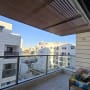 פרגולה מאלומיניום במרפסת עם נוף לבניינים
