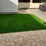 דשא סינתטי ירוק בחצר מרוצפת
