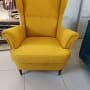 כורסה צהובה על רצפת אריחים בחנות רהיטים