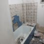 חדר אמבטיה בשיפוץ עם אריחים שבורים וכלי עבודה