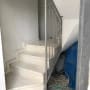 מעקה מתכת אפור על מדרגות לבנות