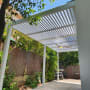 פרגולה אלומיניום בחצר עם צמחייה מסביב