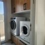ארונות עץ ומכונות כביסה בחדר כביסה