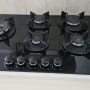 כיריים גז שחורות עם חמישה מבערים וכפתורי שליטה