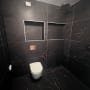 חדר אמבטיה עם קירות כהים, שירותים ומקלחת