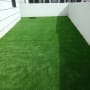 דשא סינתטי ירוק בחצר מגודרת