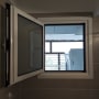 חלון אלומיניום פתוח עם מסגרת לבנה